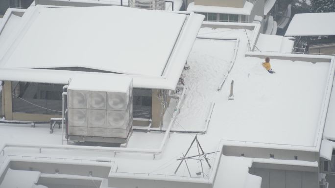 航拍冬天北方城市雪地里堆雪人玩耍的儿童