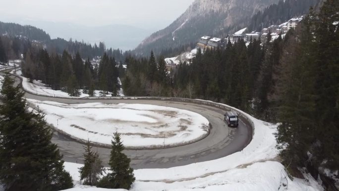 一辆装着AD和梯子的维修车，行驶在积雪的山路上