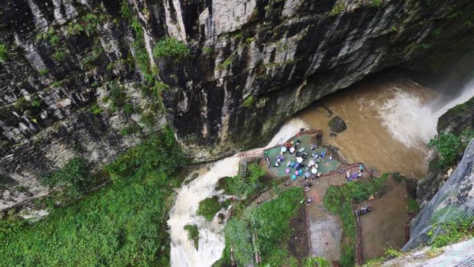 雨季的瀑布。峡谷之间湍急的瀑布河。大雨过后，泥土正在往下移。巨大翻滚的棕色浑水。4k慢动作镜头b滚拍