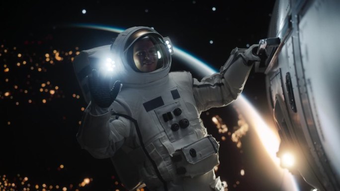 一名年轻的男宇航员在宇宙飞船、卫星或空间站外太空行走时穿着宇航服摆姿势的肖像。宇航员看着，微笑着对着