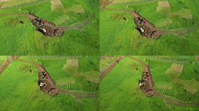 航拍镜头的反铲装载机铲土在一个绿色的田野在萨斯，阿科鲁尼亚，西班牙