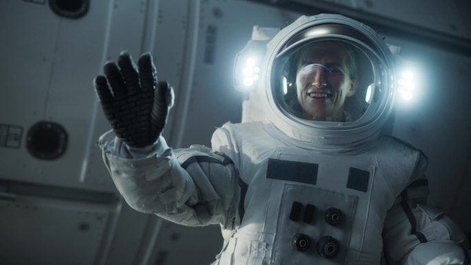 在空间站、卫星或宇宙飞船外太空行走时，一名女宇航员穿着宇航服摆姿势的肖像。快乐的女宇航员看着，微笑着
