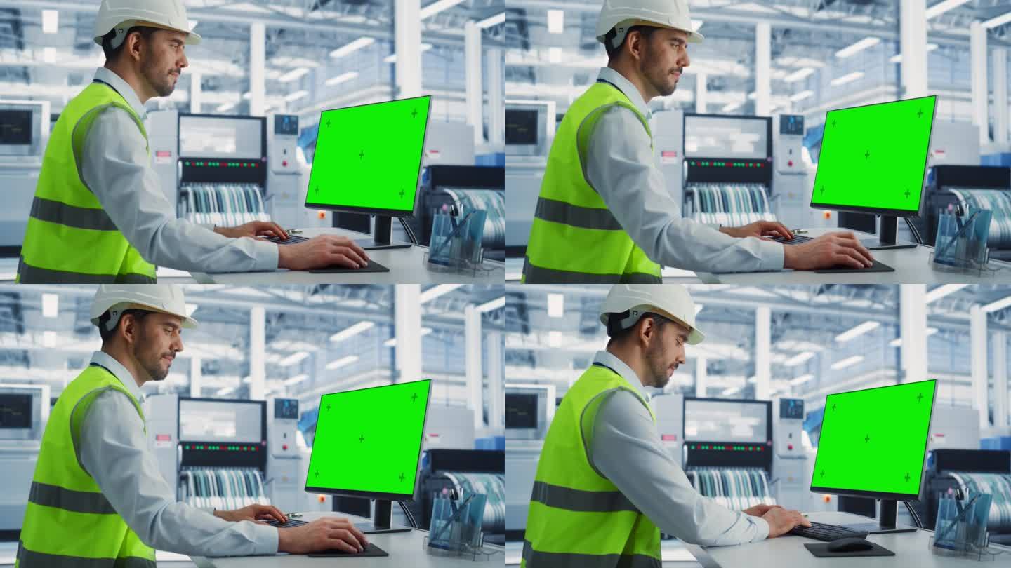 穿着防护服的白人男性工业工程师在一家电子厂的台式电脑前工作，电脑上显示着绿屏铬色。技术研发中心。