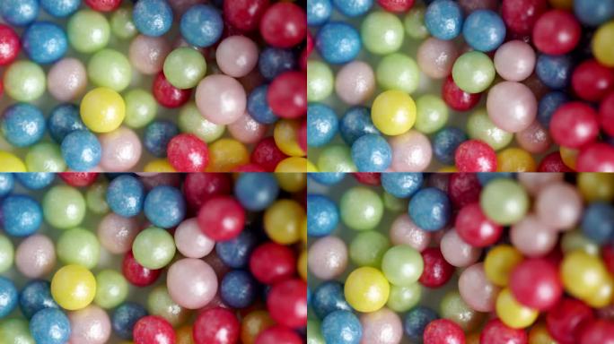 甜甜的糖屑，多色球，微距视频。五彩缤纷的糖屑旋转，装饰糖球的背景