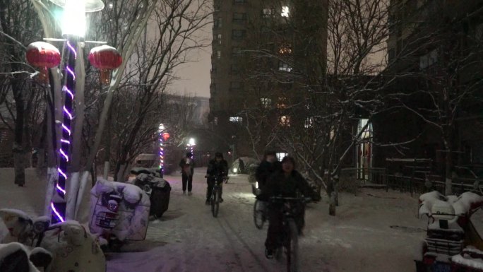 城市小区下雪春节过年行人风雪之夜雪中回家