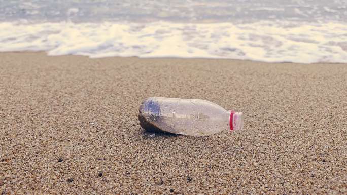 海浪冲走矿泉水瓶垃圾