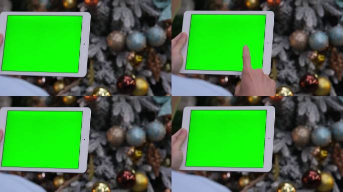 圣诞节，手使用绿色屏幕的平板电脑的慢动作