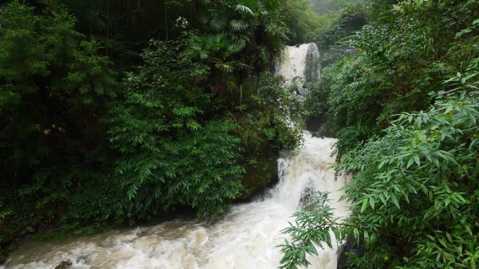 雨季的瀑布。峡谷之间湍急的瀑布河。大雨过后，泥土正在往下移。巨大翻滚的棕色浑水。4k慢动作镜头b滚拍