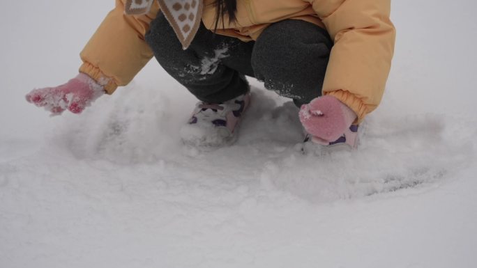 小女孩雪地玩雪