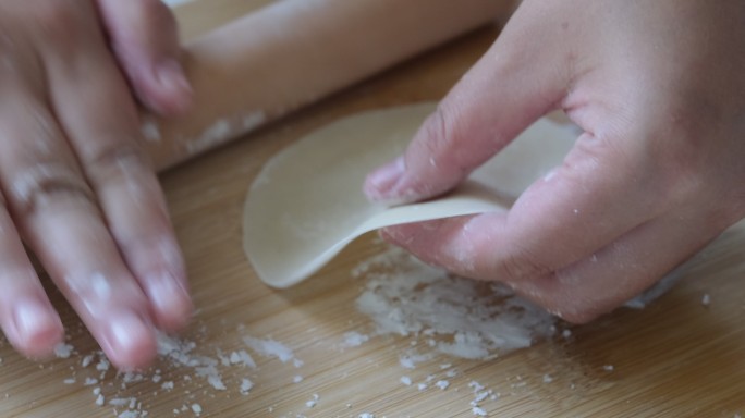 手用擀面杖擀饺子皮的慢动作特写