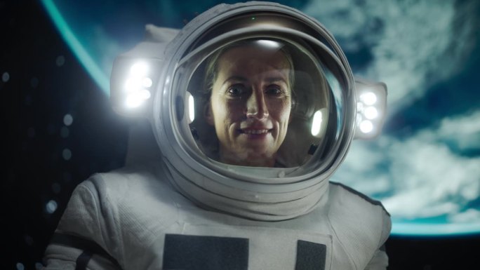 一个勇敢的女宇航员的肖像，戴着头盔和宇航服在太空中，漂浮在零重力和惊奇地看着相机。太空旅行，太阳系探
