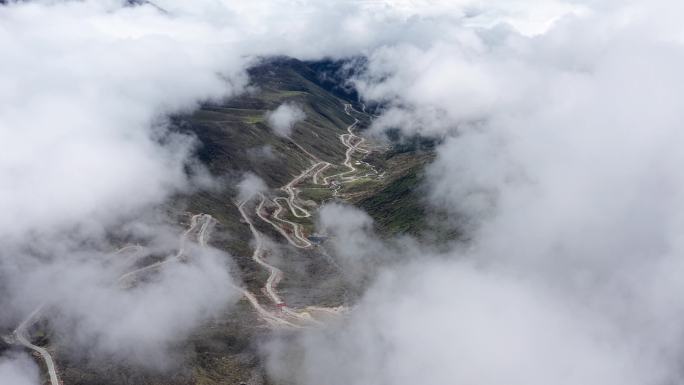 雪山下云海云雾中蜿蜒的盘山公路