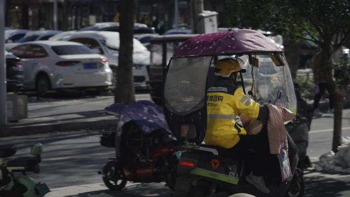 美团外卖小哥骑电动车在城市穿梭送外卖