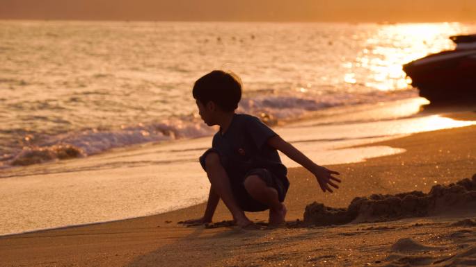 海边玩沙的小孩 夕阳