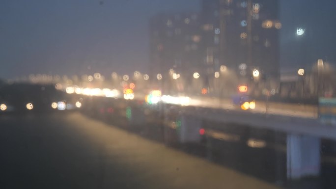 夜晚的大桥下着雨车辆经过形成光斑