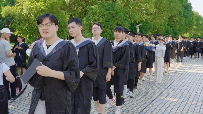 晴朗夏日青春大学生穿学士服拍毕业照准备