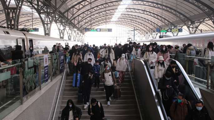 很多旅客从火车站站台下楼梯出站，春运人潮