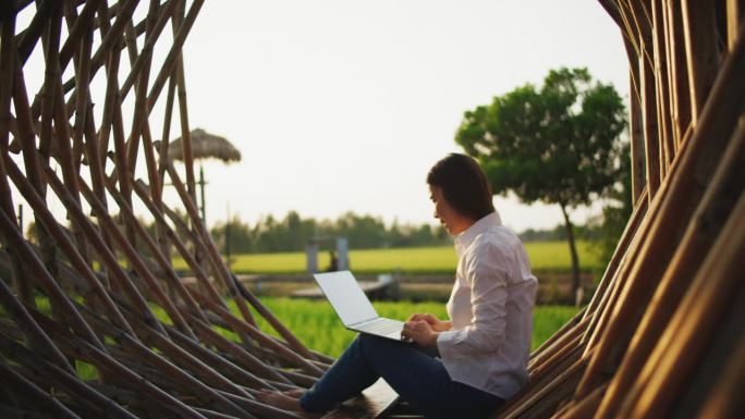 数字游牧民概念亚洲自由职业者妇女使用笔记本电脑在水稻绿色露台