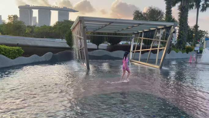 夕阳下城市中的儿童嬉戏亲水喷泉视频