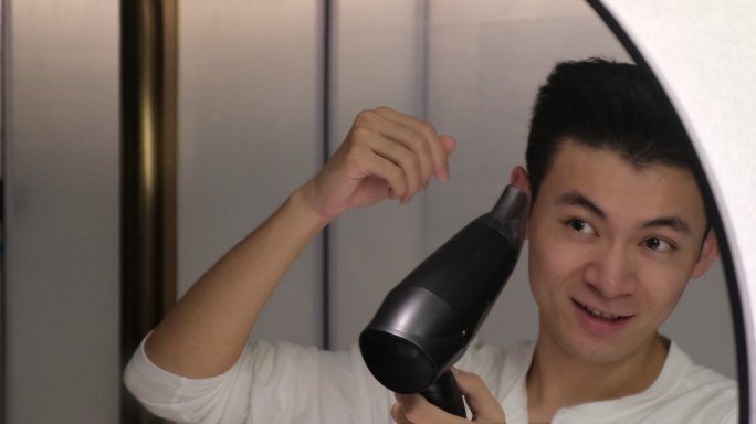 年轻中国帅哥用电吹风吹头发