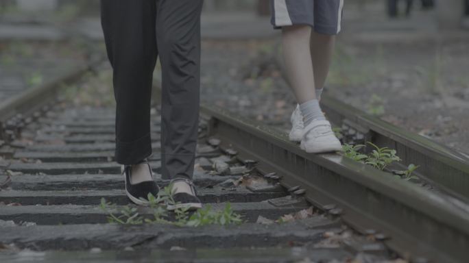 下雨天师生走在铁轨上