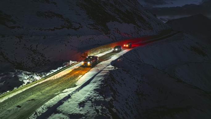 夜晚雪地雪山上行驶的汽车