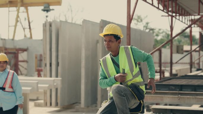 建筑工人熟练地在工地切割混凝土墙。熟练工人操作电动工具，在建筑工地切割混凝土墙-高强度劳动活动。