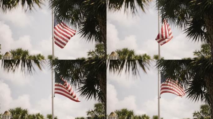 美国国旗在风中缓慢飘扬，明亮的天空和热带树木