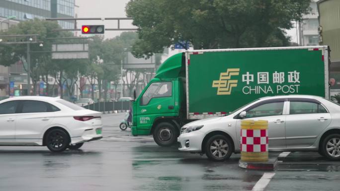 邮政车风雨天行驶在路上