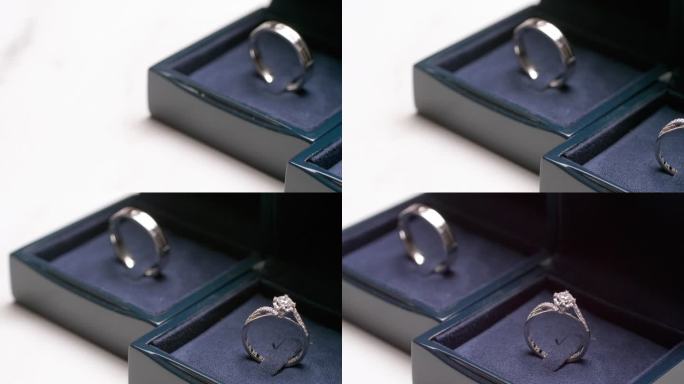 一对夫妇的订婚戒指的特写，放在一个深蓝色的天鹅绒覆盖的盒子里。