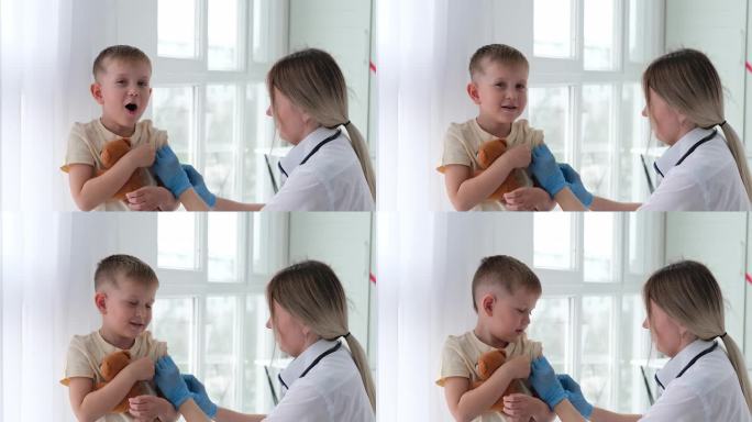 戴着医用口罩的医生给孩子的肩膀打针。疫苗接种,疫苗。护士给孩子注射疫苗。孩子们在诊所里。一个小男孩打