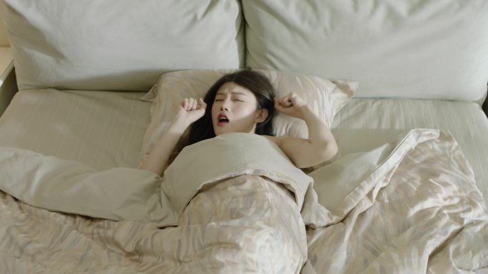 女孩床上伸懒腰 睡眠好