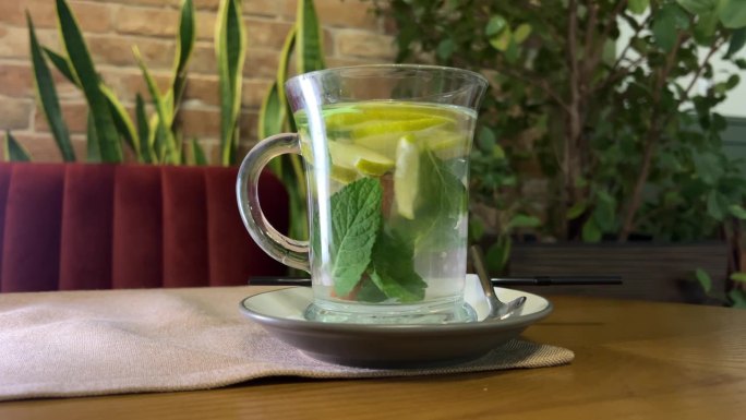 一杯白色的天然绿茶，加入生姜、柠檬和蜂蜜