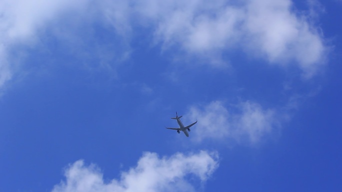 客运飞机在蓝天白云上空飞行