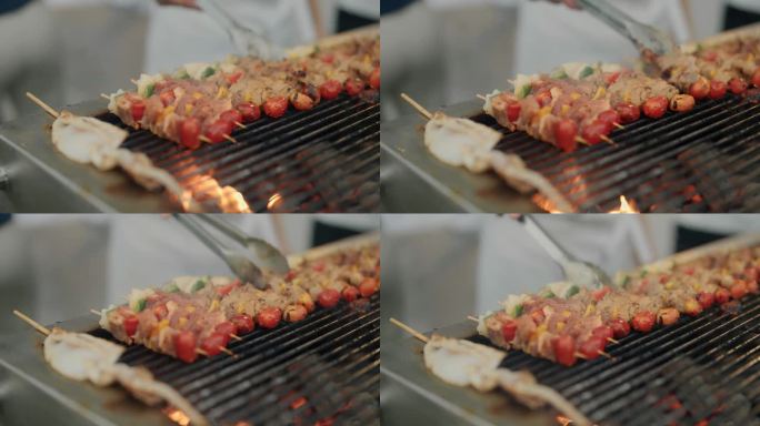 烧烤的特写，烤肉串上串着西红柿，在木炭烤架上烤着。