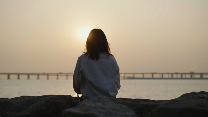 夕阳海边女生背影看海