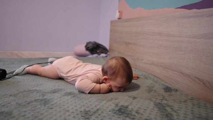 白种女婴躺在床上咀嚼吹风机电缆
