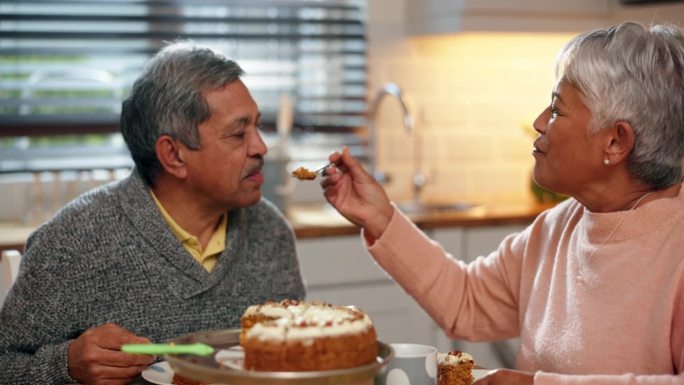 喜气洋洋，大饼和老两口在厨房吃着茶点，在家里亲密无间。爱情，浪漫和退休的老妇人在家里的餐桌上给丈夫吃