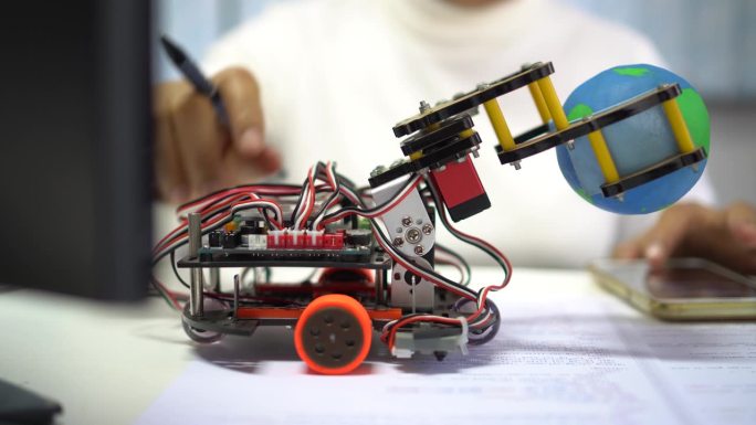 机器人电子在学校的实验室，STEM教育的学习，让学生学习科学技术的电子板。机器人抱球模型通过编码编程