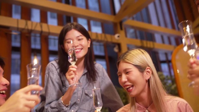 年轻的亚洲华人朋友在餐厅、咖啡厅、酒廊和联合办公空间啜饮香槟，享受气泡和清爽的味道。