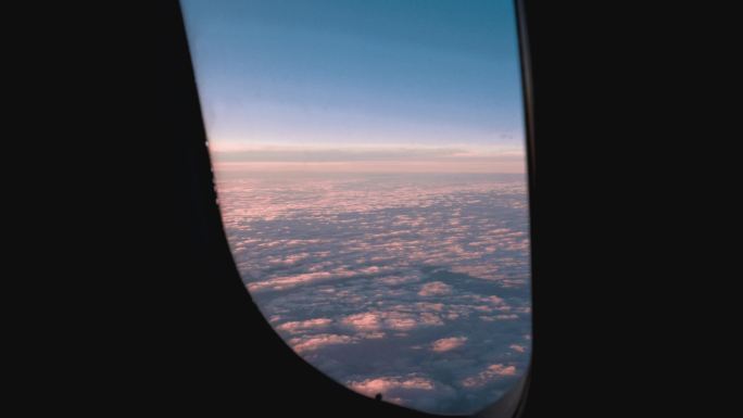 飞机窗外落日时分夕阳下的云海红色晚霞