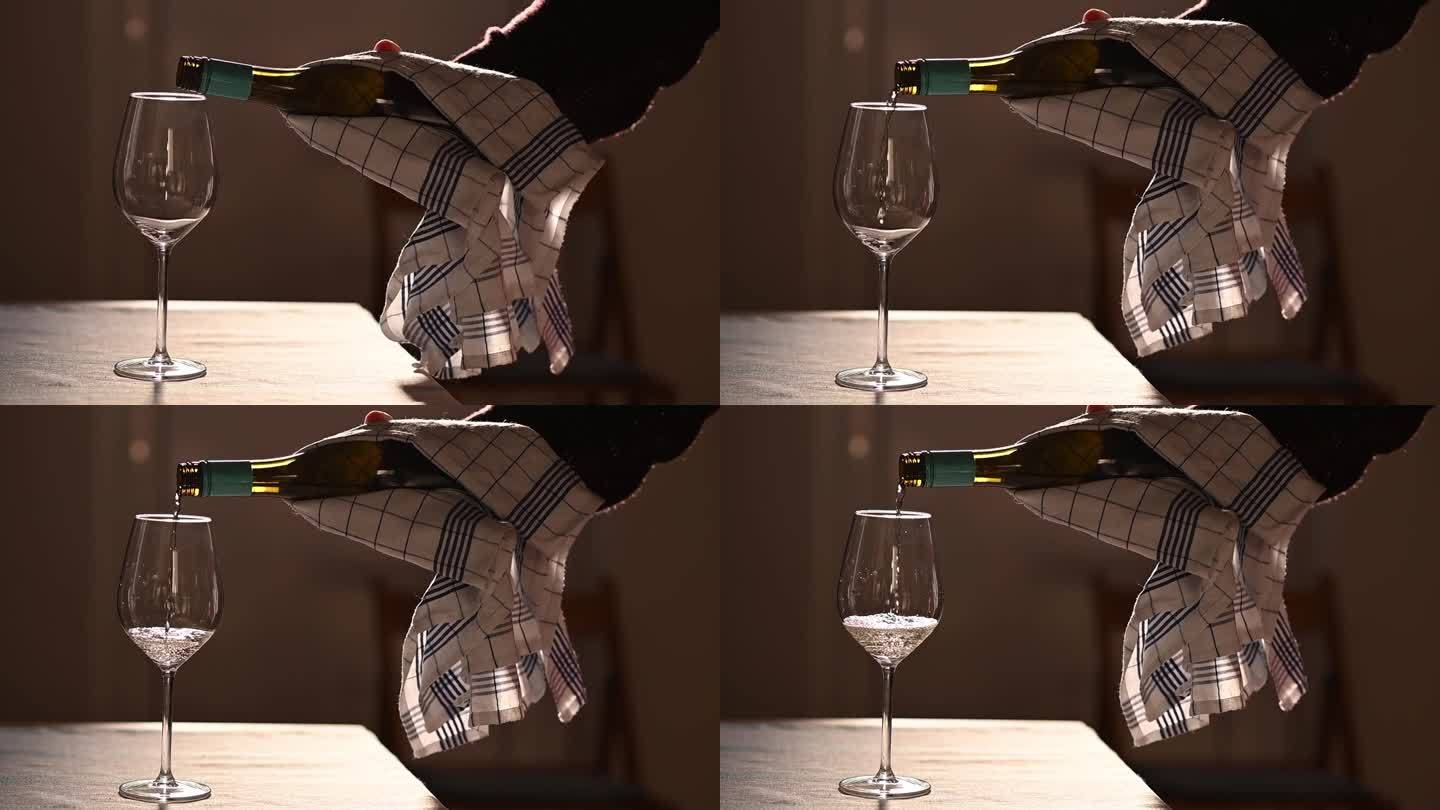 把白葡萄酒倒进靠在木桌上的玻璃杯里。饮料