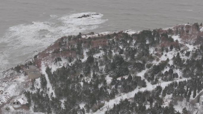 航拍威海高区后荆汪海边礁石海浪山崖雪景