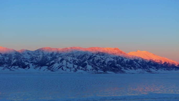 航拍新疆冬季赛里木湖日照金山雪山夕阳雪景