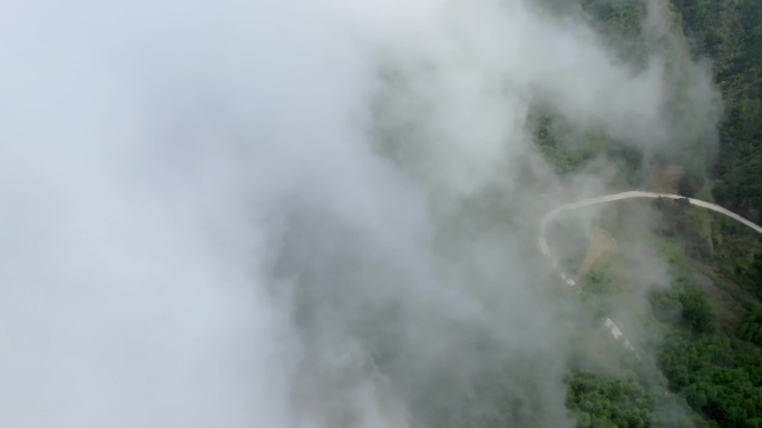 群山丛林间云雾里的电力铁塔