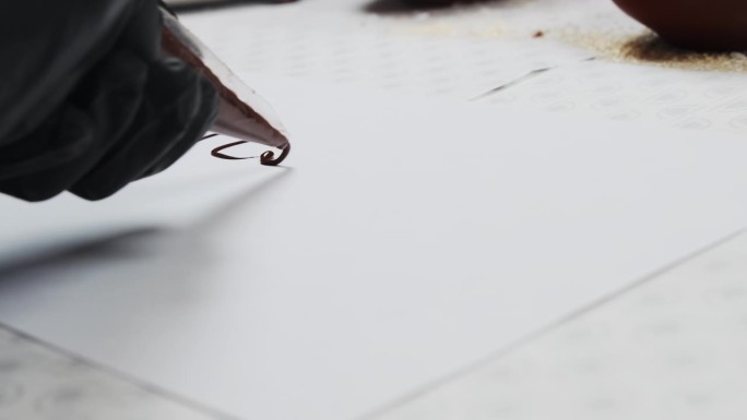 人们用巧克力液体书写文字，用一张纸做背衬