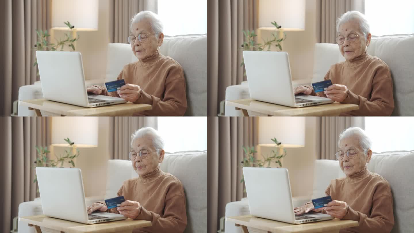 戴着眼镜、满头白发的老妇人坐在客厅里，手里拿着银行卡，用着智能手机