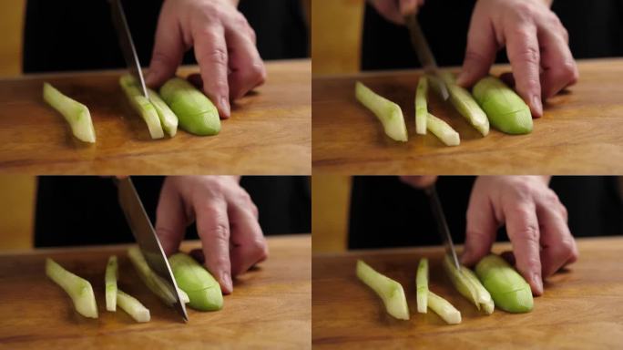 用刀把新鲜黄瓜切成小块。做黄瓜菜。缓慢的运动。