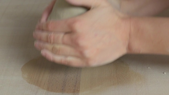 陶艺师用手准备粘土，准备在抛轮上工作