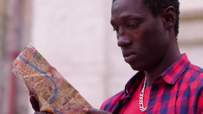 年轻的美国非洲游客在罗马地图上寻找正确的方向